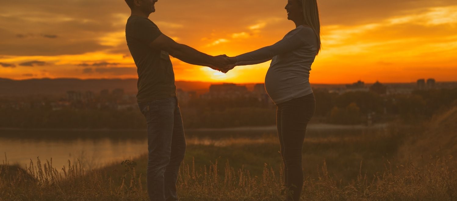 A couple holding hands on a babymoon
