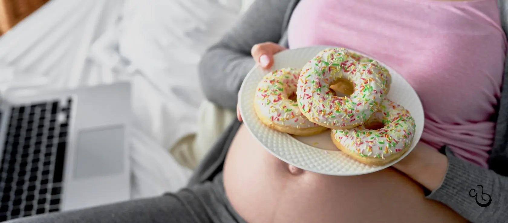 Pregnant woman craving sprinkled donuts while relaxing in bed.
