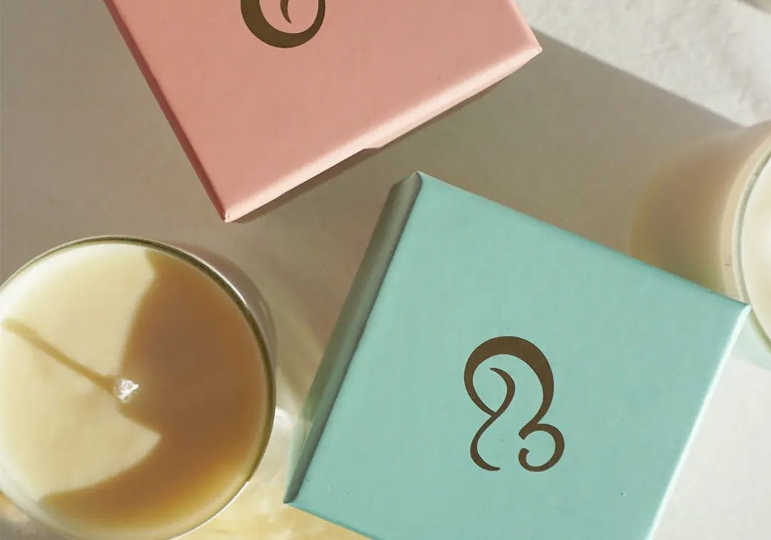 Top view of Mum and Baby Candle with teal and pink Cradle & Tonic packaging, highlighting its premium aromatherapy gift appeal.